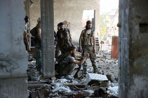 Rebel fighters speak during clashes with regime forces in Ramussa, Aleppo on Aug. 6.