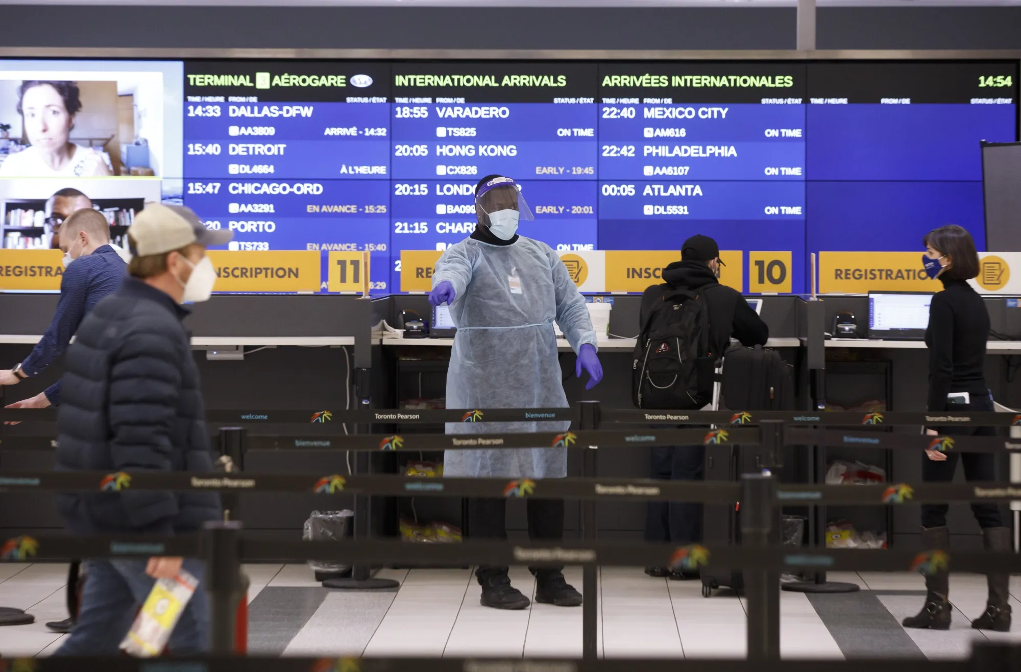 A healthcare worker directs travelers to a mandatory Covid-19 testing area at Pearson airport&nbsp;in Toronto.