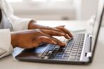 Woman typing on her laptop keyboard