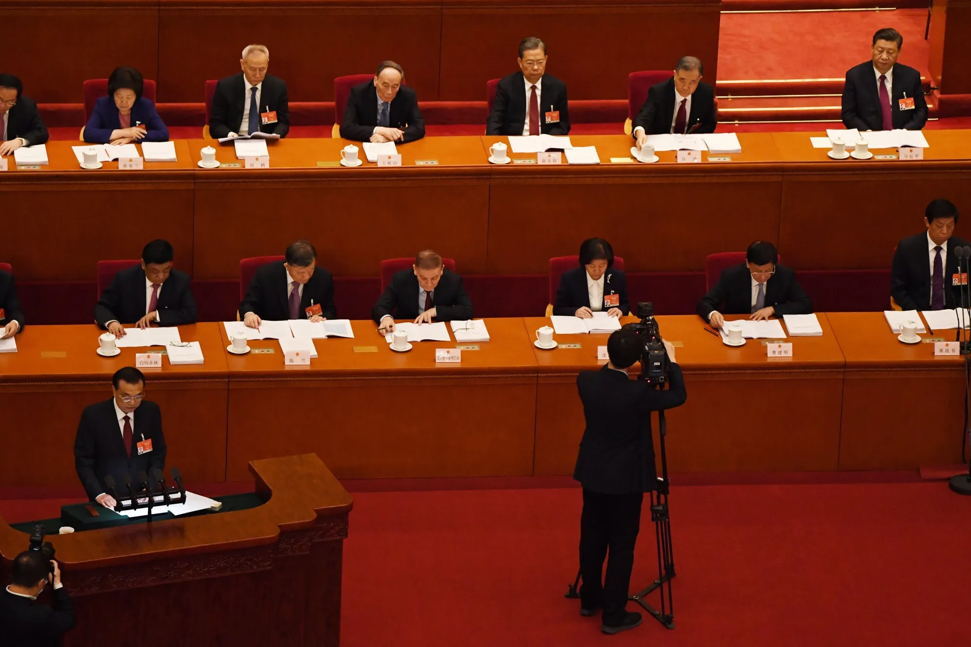 Li Keqiang , left, reads his work report during the opening session of the National People’s Congress at the Great Hall of the People in Beijing on March 5.