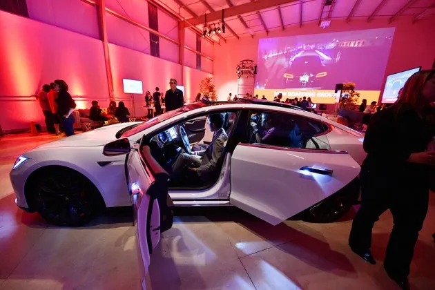 Tesla owners look at the interior of the Tesla “D” electric sedan after Elon Musk unveiled the dual-engine chassis—a faster, all-wheel-drive version of the Model S