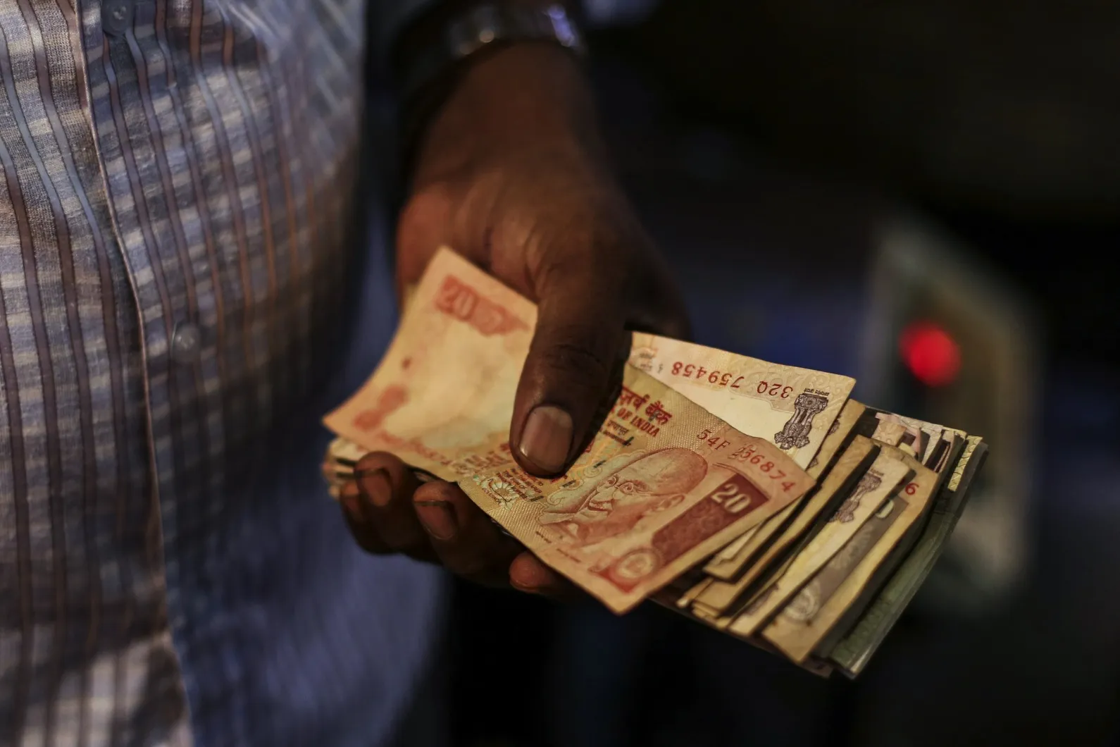 A vendor holds Indian rupee notes in Mumbai.