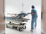 Nurse wheeling patient to surgery OR