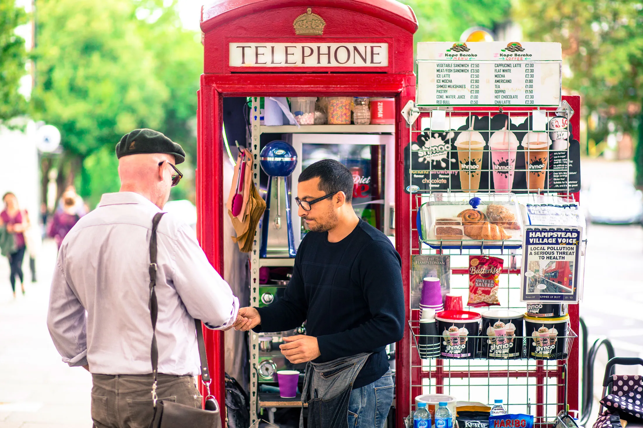 Umar Khalid, co-owner of the Kape Barako phone booth coffee stall, serves a customer.
