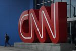A pedestrian passes in front of CNN signage displayed at the network's headquarters building in Atlanta, Georgia.