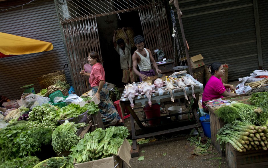 Street vendors sell vegetables and chickens in Yangon.