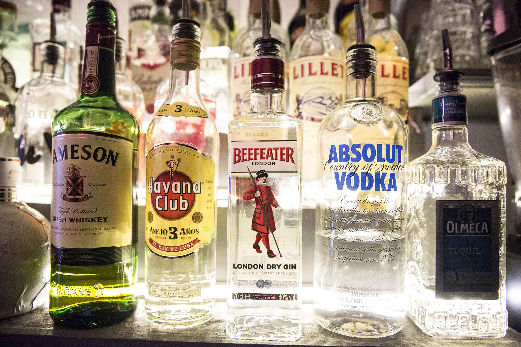 Left to right, bottles of Jameson Irish whiskey, Havana Club rum, Beefeater gin, Absolut Vodka, and Olmeca tequila, all produced by Pernod Ricard SA, sit on a shelf in a restaurant in Paris, France, on Tuesday, Aug. 25, 2015. Pernod Ricard SA, Europe’s second-biggest distiller, owner of Absolut vodka, Chivas Regal whisky and Ricard Pastis report full year results tomorrow.
