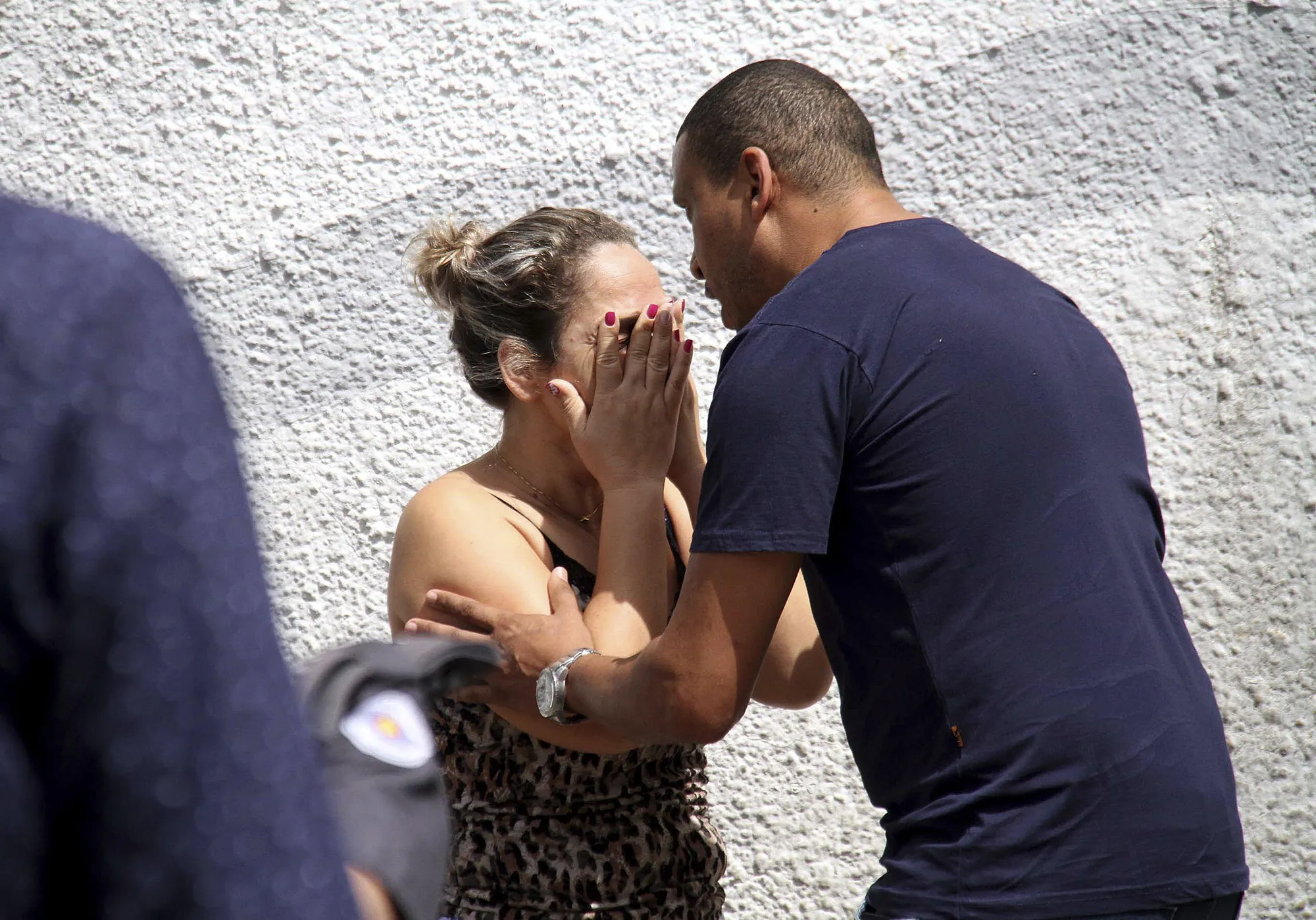 A man comforts a woman at the Raul Brasil State School in Suzano, Brazil on March 13, 2019.&nbsp;