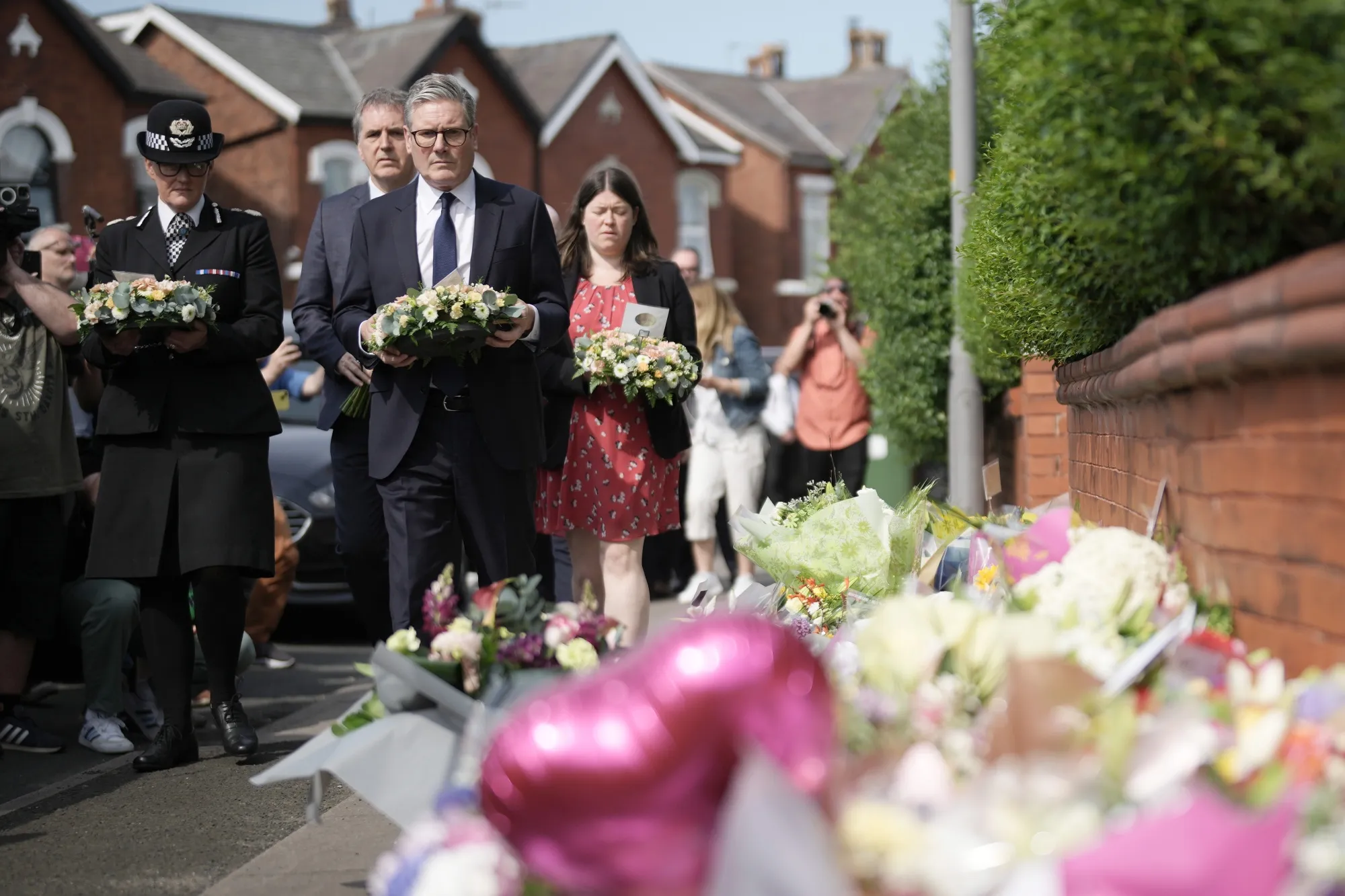 Keir Starmer arrives with a floral tribute to the victims of a knife attack in Southport, England on July 30.