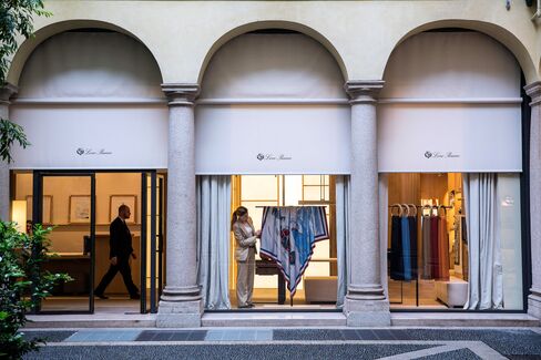 A Loro Piana employee adjusts a window display at a company store in Milan.