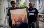 Armin Prude, left, and Joe Prude hold an enlarged photo of Daniel Prude, Sept. 3, 2020, who died following a police encounter, in Rochester, New York. 