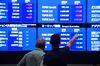 Visitors look at screens displaying stock indices at the Tokyo Stock Exchange (TSE), operated by Japan Exchange Group Inc. (JPX), in Tokyo, Japan, on Tuesday, July 24, 2018. Japanese shares rose with banks contributing the most to the Topix’s advance, after bond yields climbed around the globe on speculation the Bank of Japan may tweak its monetary policy.