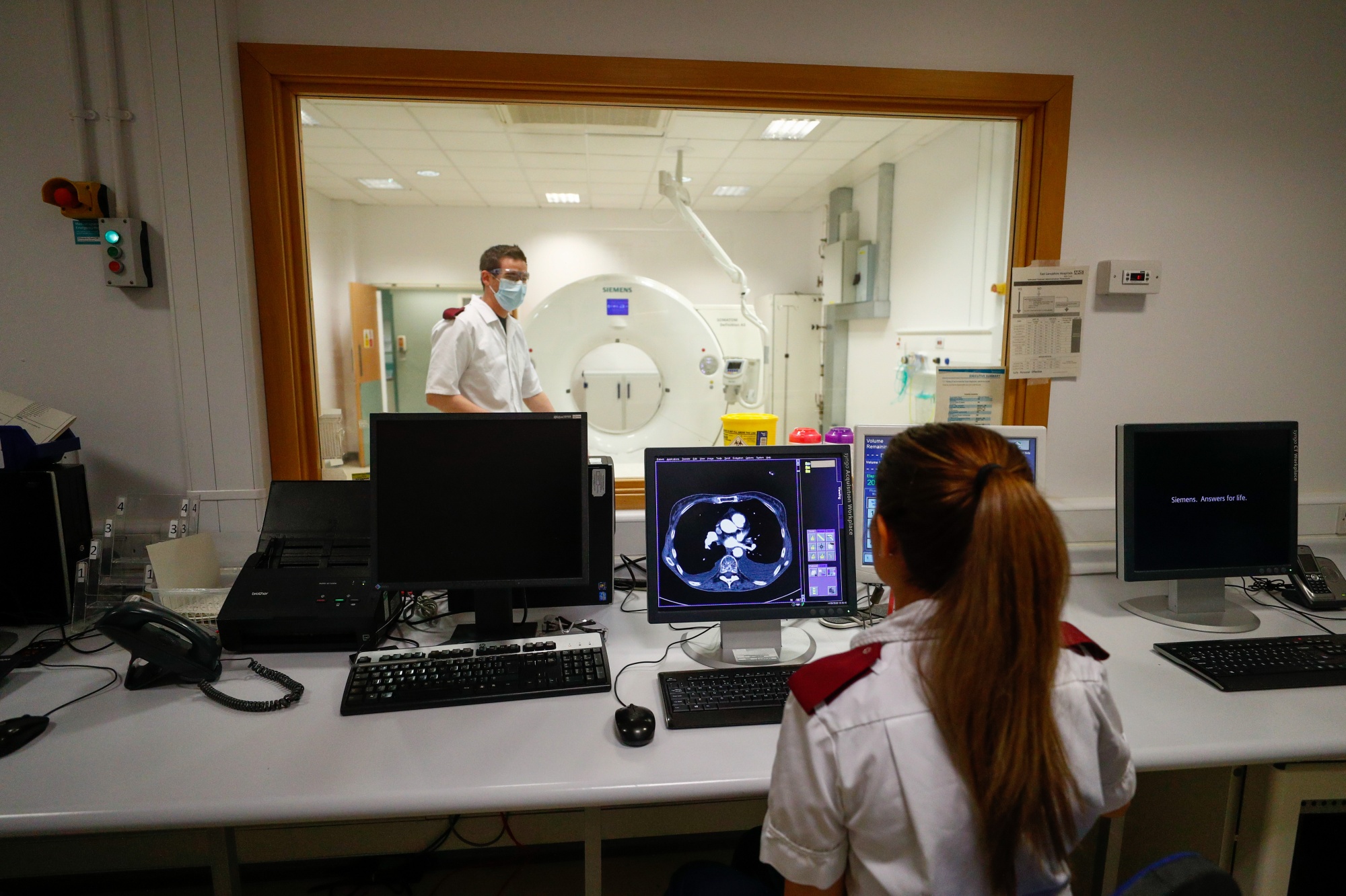 Medical staff prepare to receive a patient for a CT scan at The Royal Blackburn Teaching Hospital, operated by East Lancashire NHS Trust, in Blackburn, U.K., on Thursday, May, 14, 2020. Delivering his Budget on March 11, U.K. Chancellor of the Exchequer Rishi Sunak said “whatever extra resources our NHS needs to cope with Covid-19, it will get.” Photographer: Hannah McKay/Reuters/Bloomberg