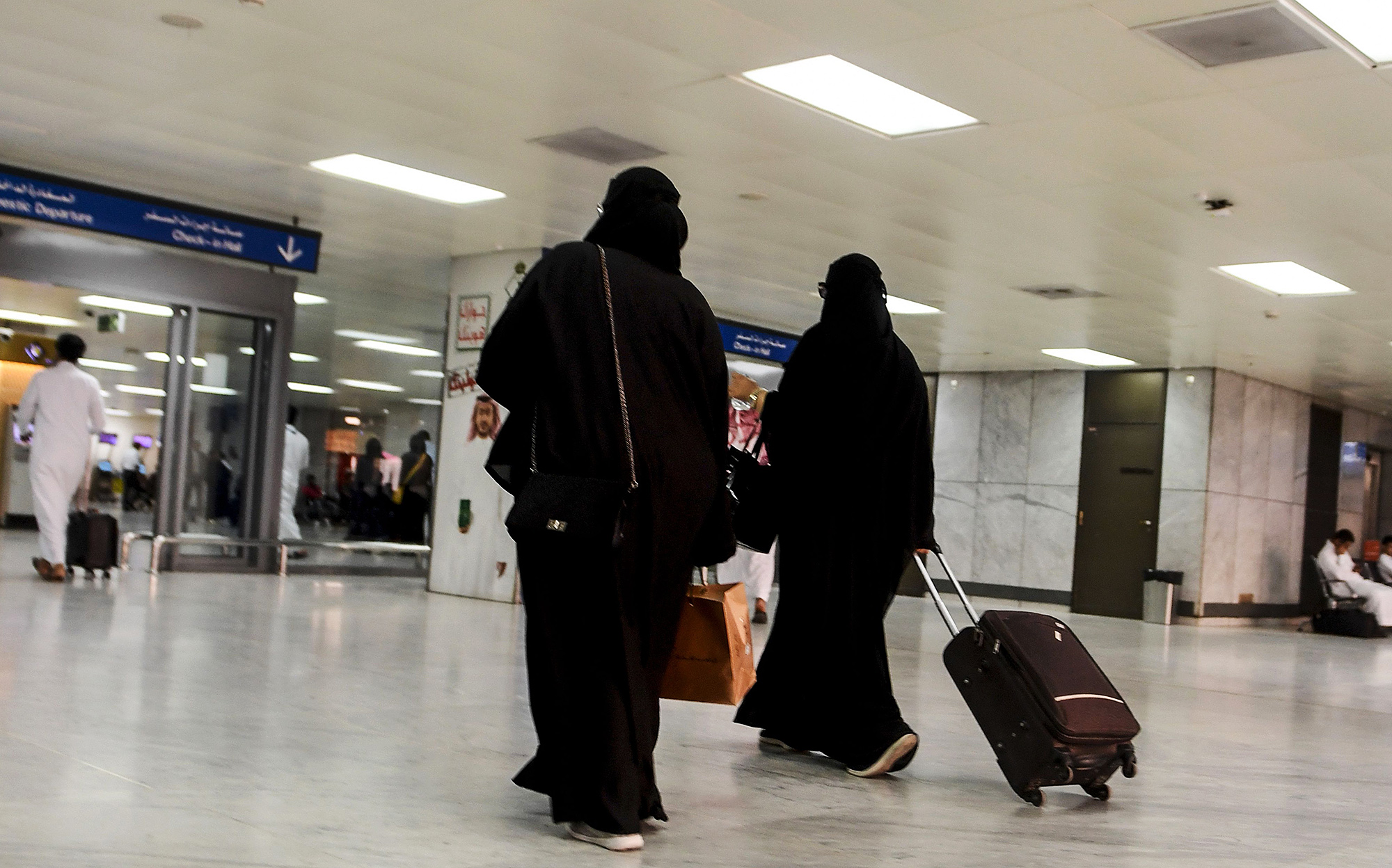Saudi women roll at the departure hall of the Jeddah Airport on Aug. 6.