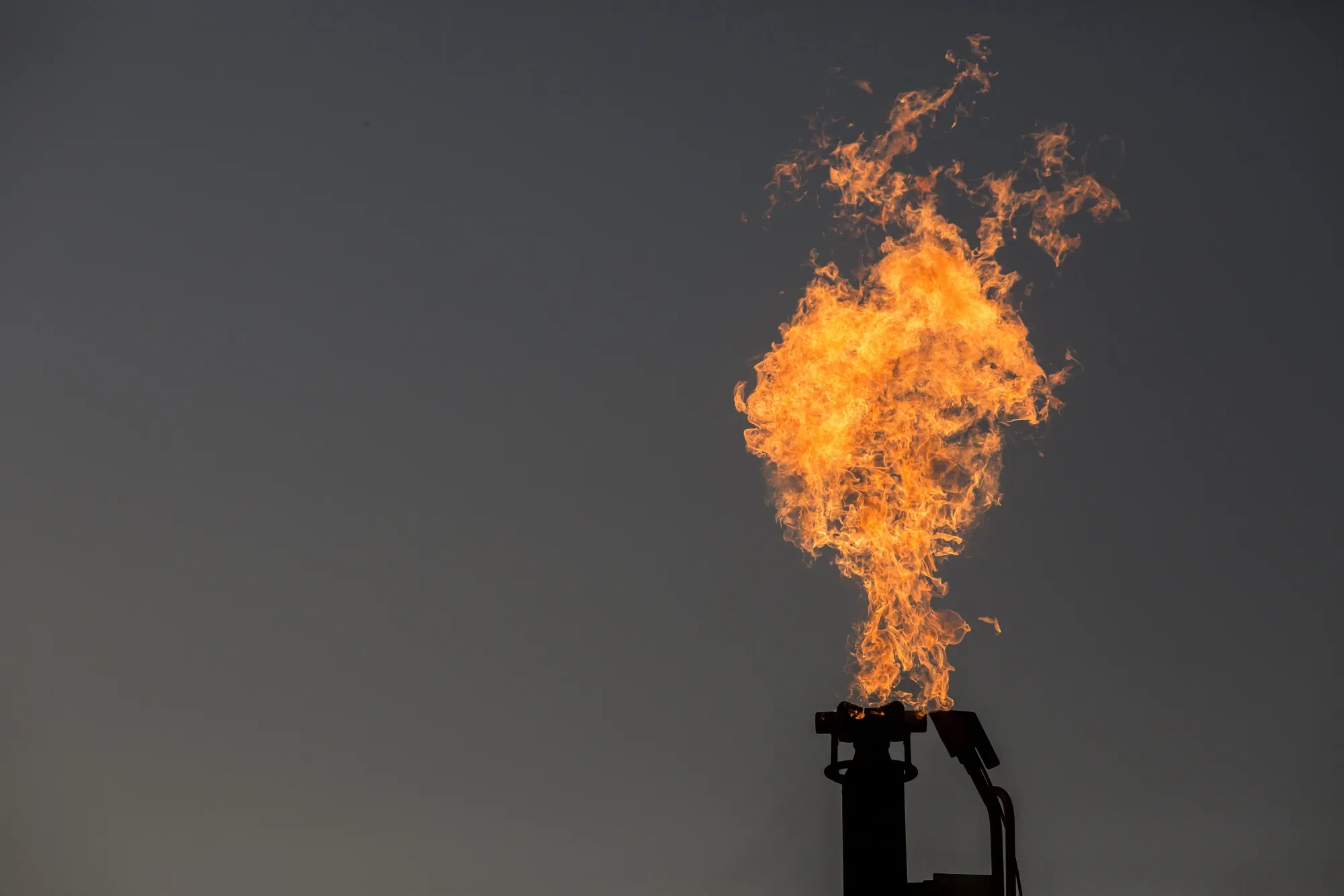 A gas flare is in a field at dusk near Pecos, Texas, last year.