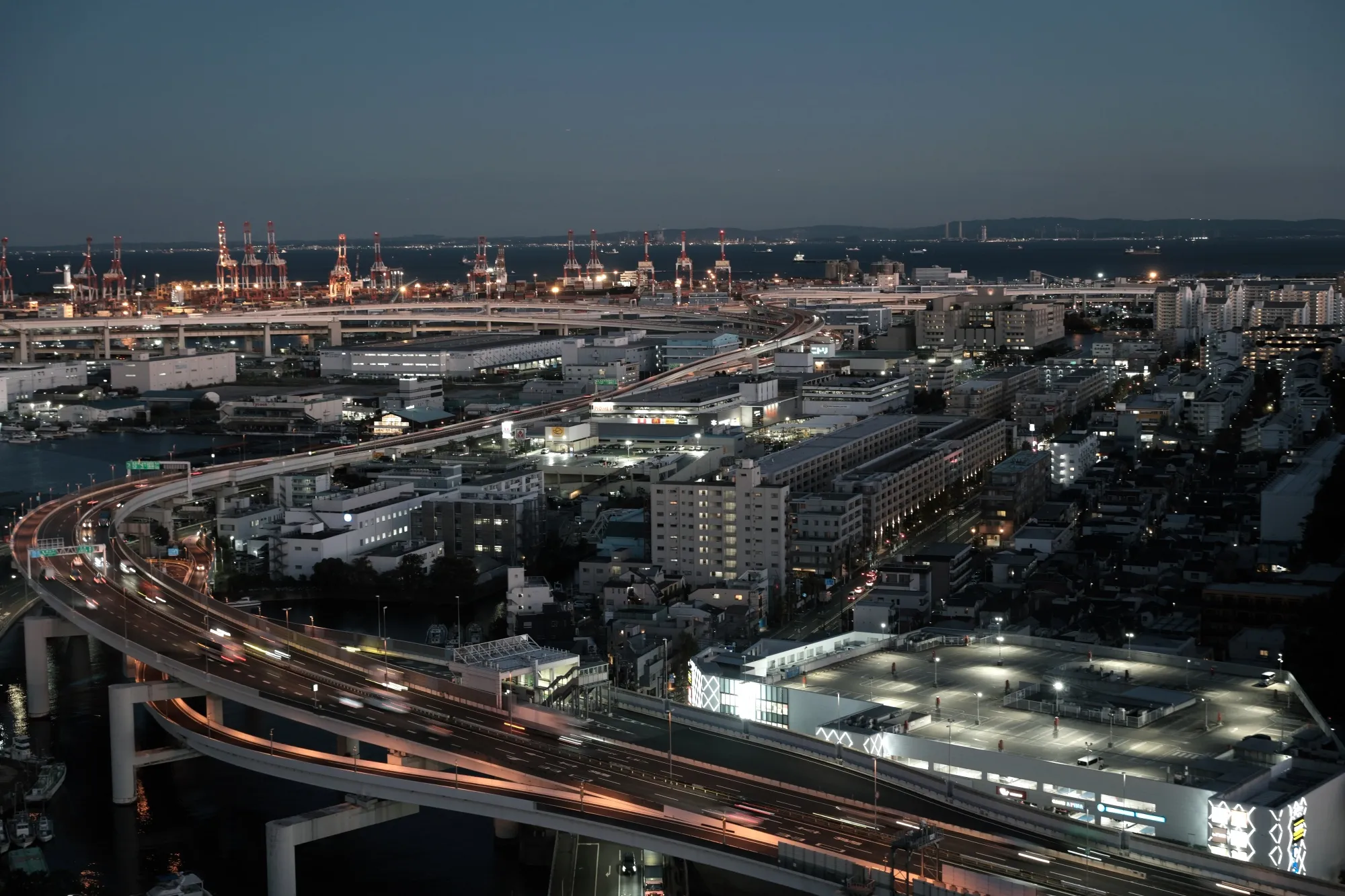Vehicles travel on highways at dusk in Yokohama.