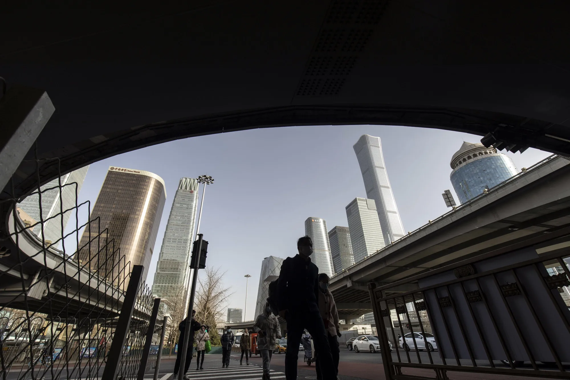 Pedestrians pass buildings in Beijing.