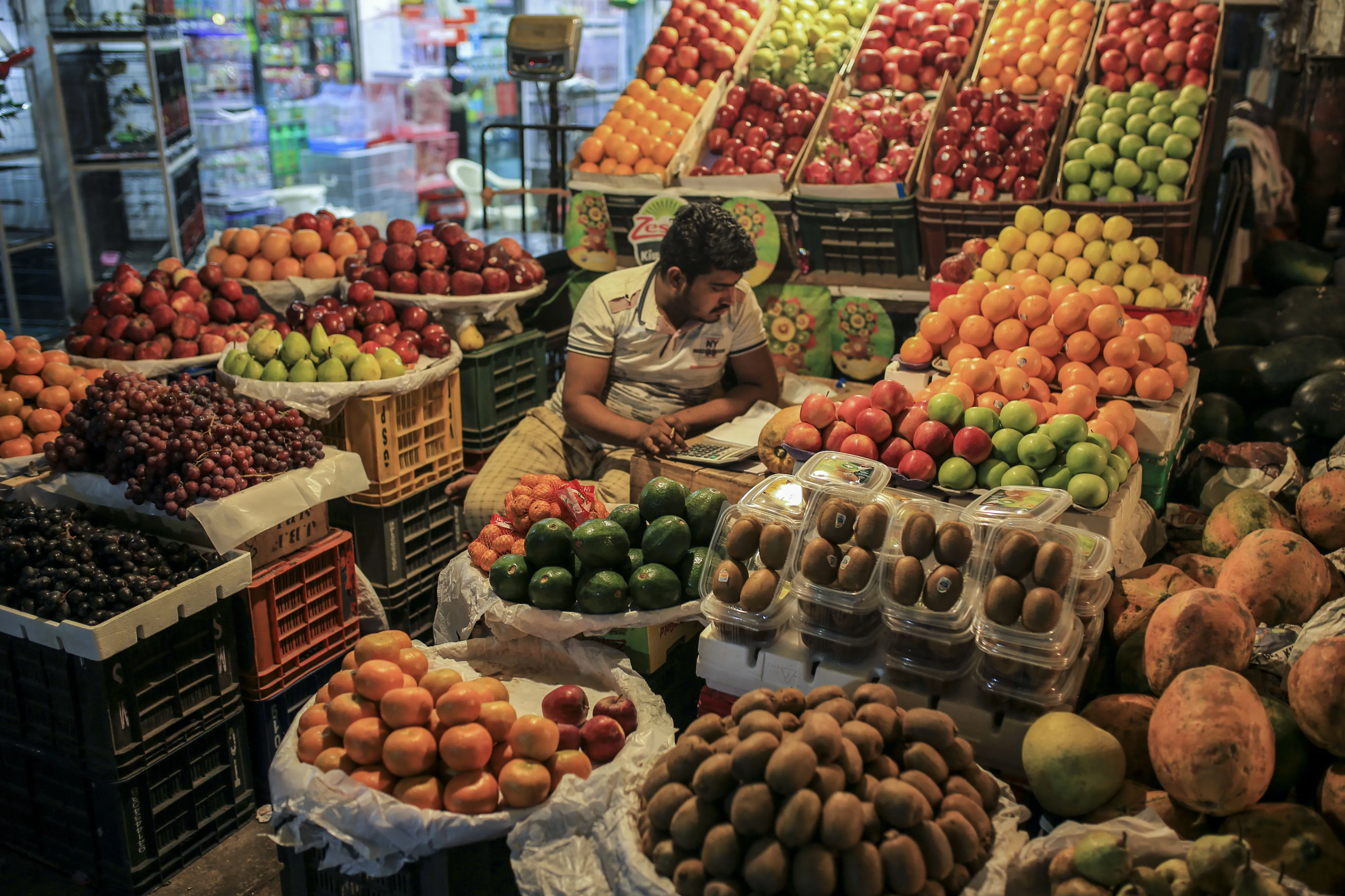 A vendor sits at a fruit stall at Crawford Market in Mumbai.