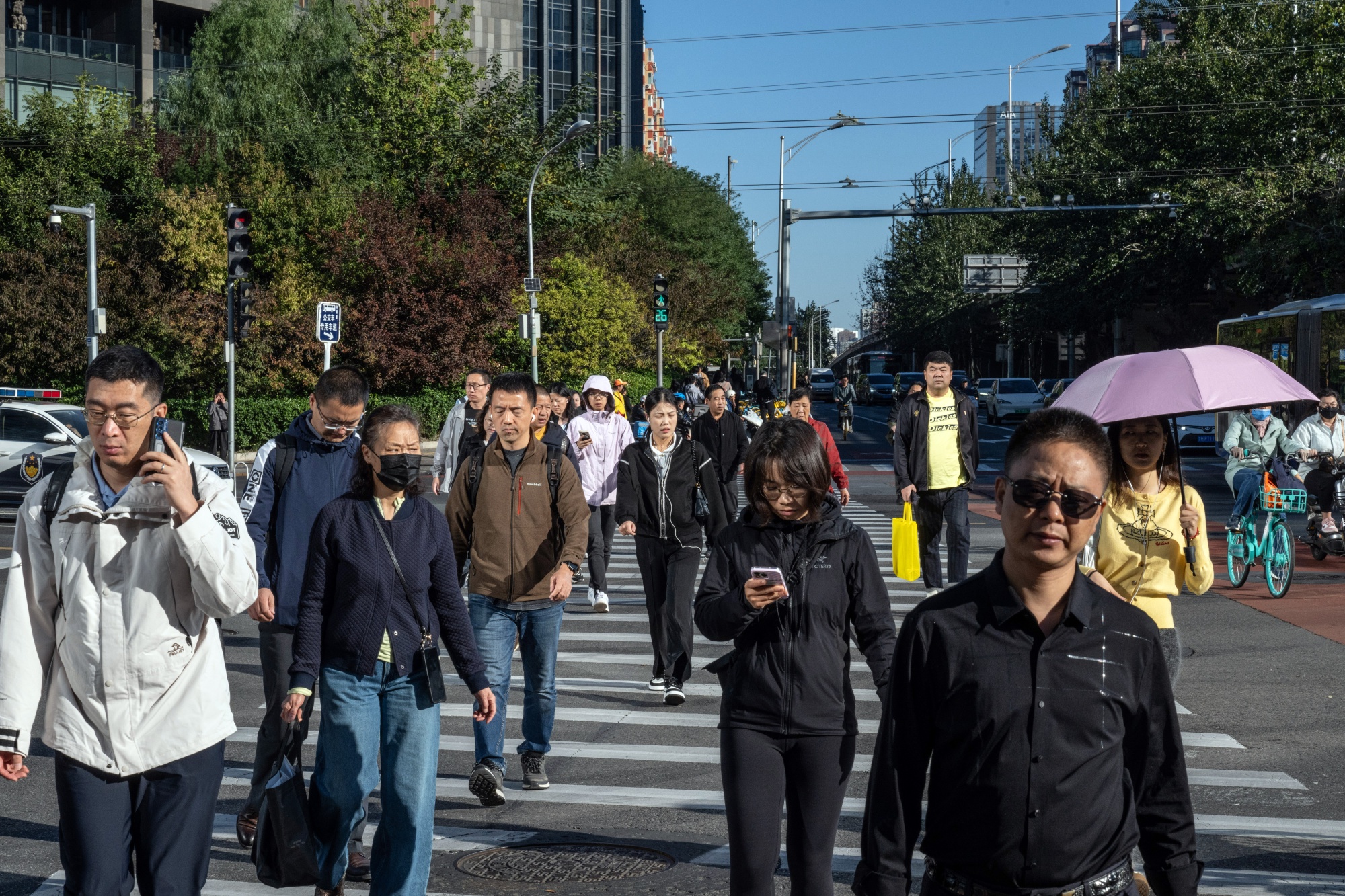 Pedestrians cross a road in Beijing, China, on Tuesday, Oct. 8, 2024. China said it's confident in reaching its economic targets this year and promised to further support growth, although it held back in unleashing more major stimulus in a disappointment to investors looking for more fuel for a world-beating stock rally.