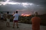 Residents watch a wildfire in the town of Rafina, near Athens, Greece in July 2018. Mediterranean nations have spent around 200 billion euros in the past two decades to build up some of the world’s largest firefighting forces. 