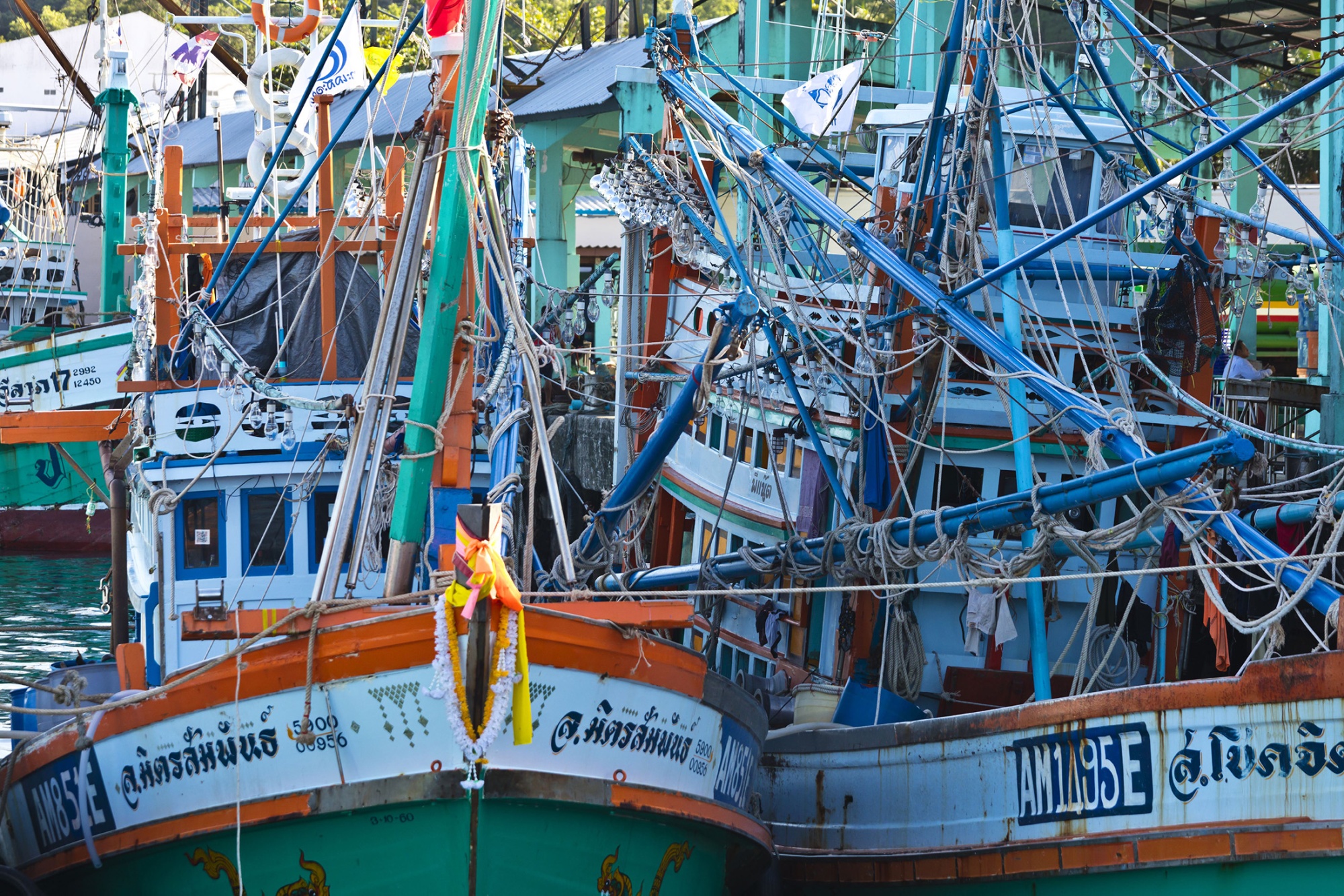 Fishing boats sit anchored at a pier in Thailand.