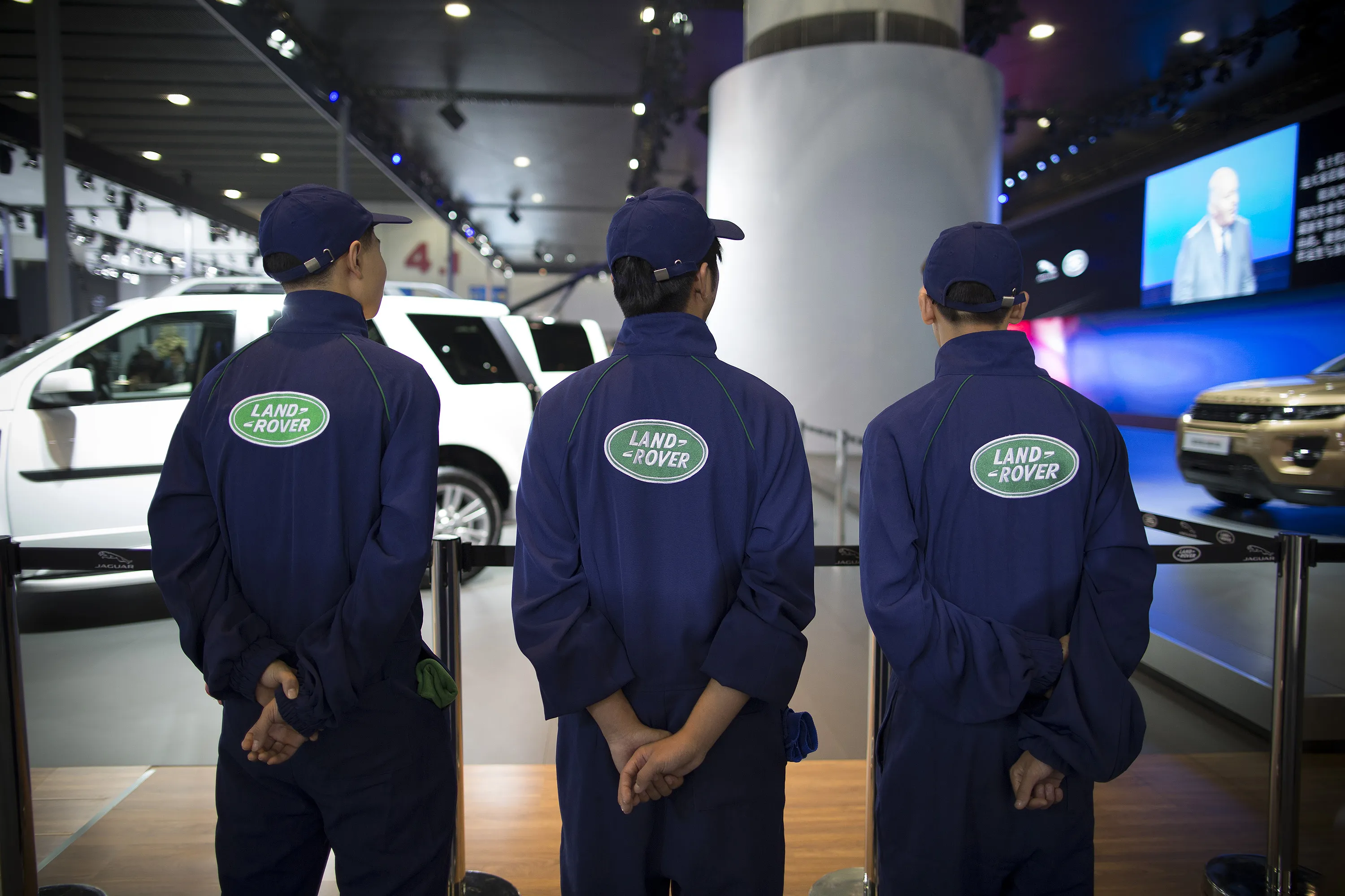 Workers stand at the booth for Land Rover vehicles, manufactured by Tata Motors Ltd.'s Jaguar Land Rover unit, at the 11th China International Automobile Exhibition in Guangzhou, China, on Nov. 21, 2013.
