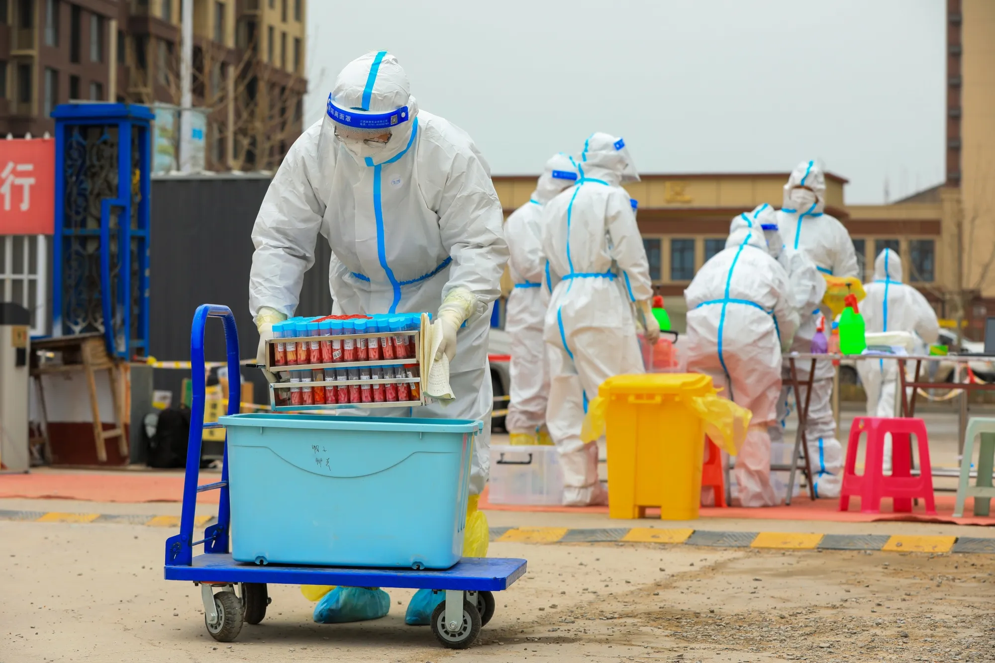 A medical worker transports a box of swab samples collected for Covid-19 tests to a mobile nucleic acid testing vehicle in Tangshan on March 29..