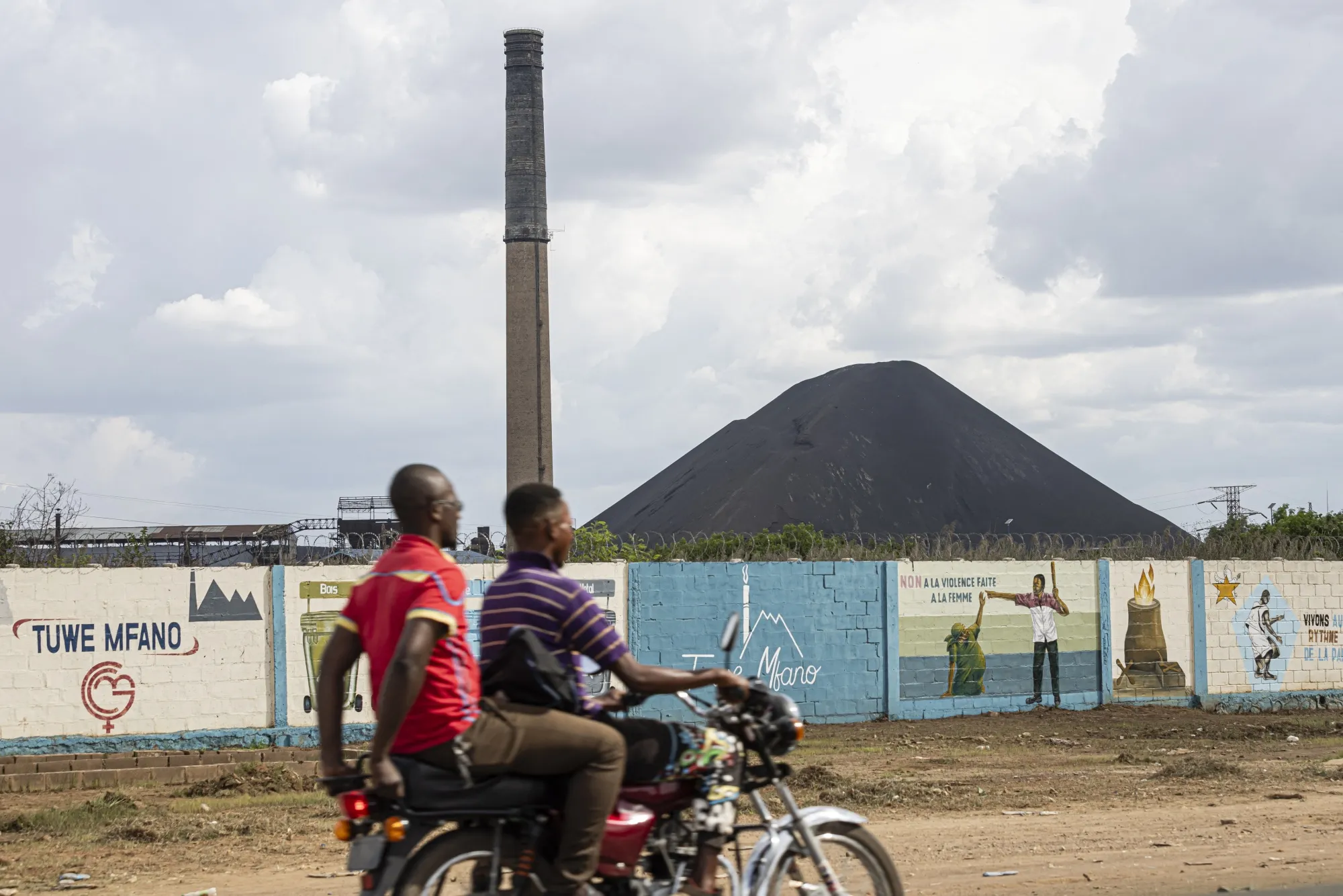 A motorcycle rides past the Gecamines mining complex in Lubumbashi, Democratic Republic of Congo.&nbsp;