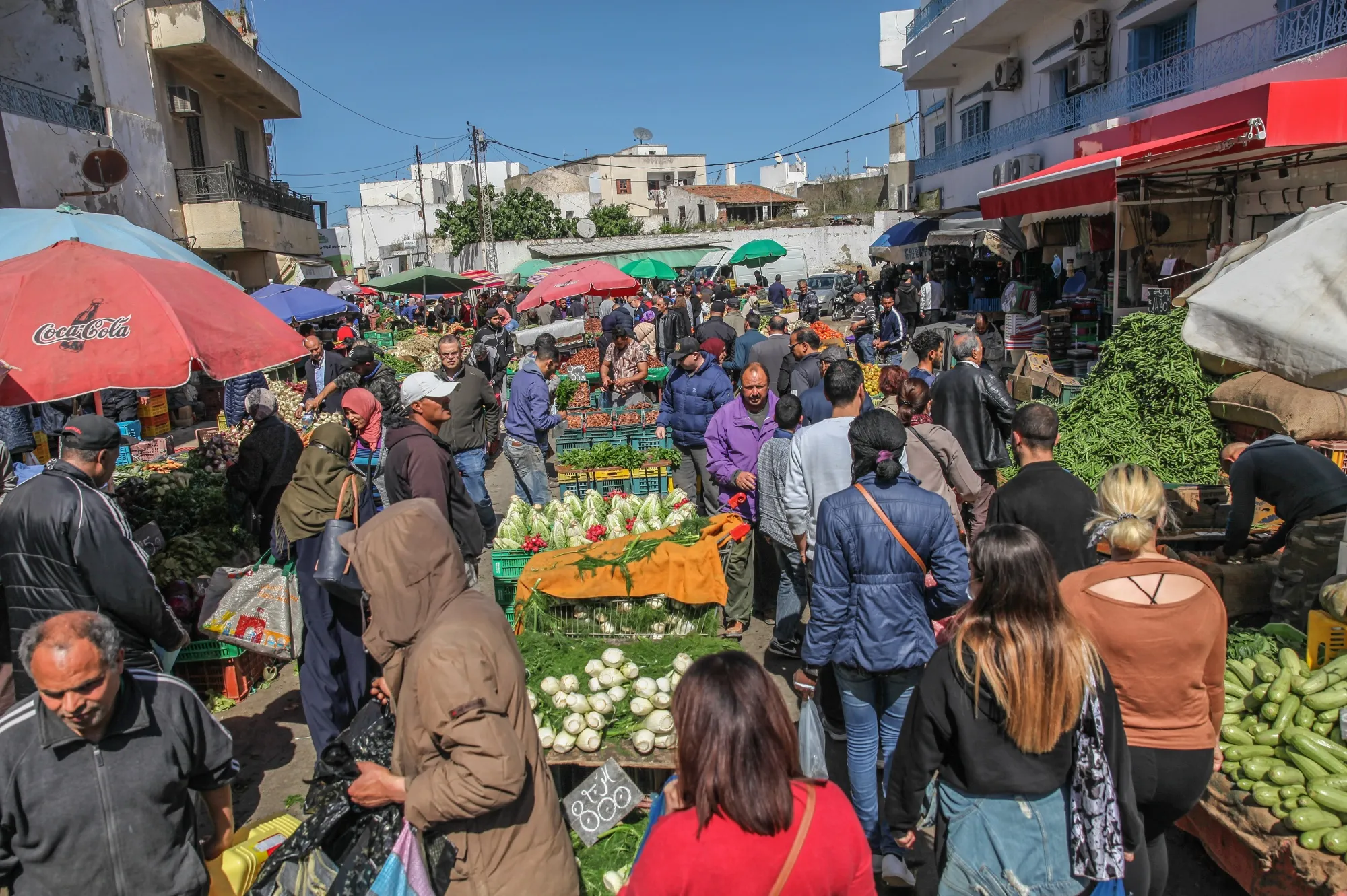 Customers shop for fresh produce at a street market in the Ariana district of Tunis, Tunisia.