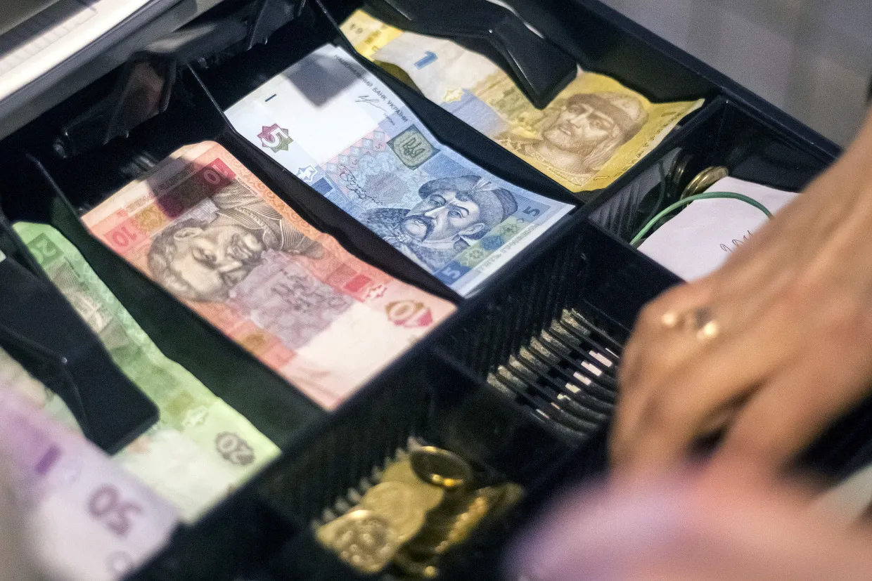 Mixed denomination hryvnia banknotes sit in a cash till at a store in Kiev, Ukraine, on Tuesday, March 4, 2014. Moscow's move to seize control of the Black Sea region triggered a sell-off in global equities and currencies from Russia to Turkey yesterday.