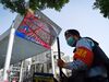 A security volunteer stands in front of an outdoor screen showing live coverage of the closing session of the National Peoples Congress (NPC) in Beijing on May 28, 2020.