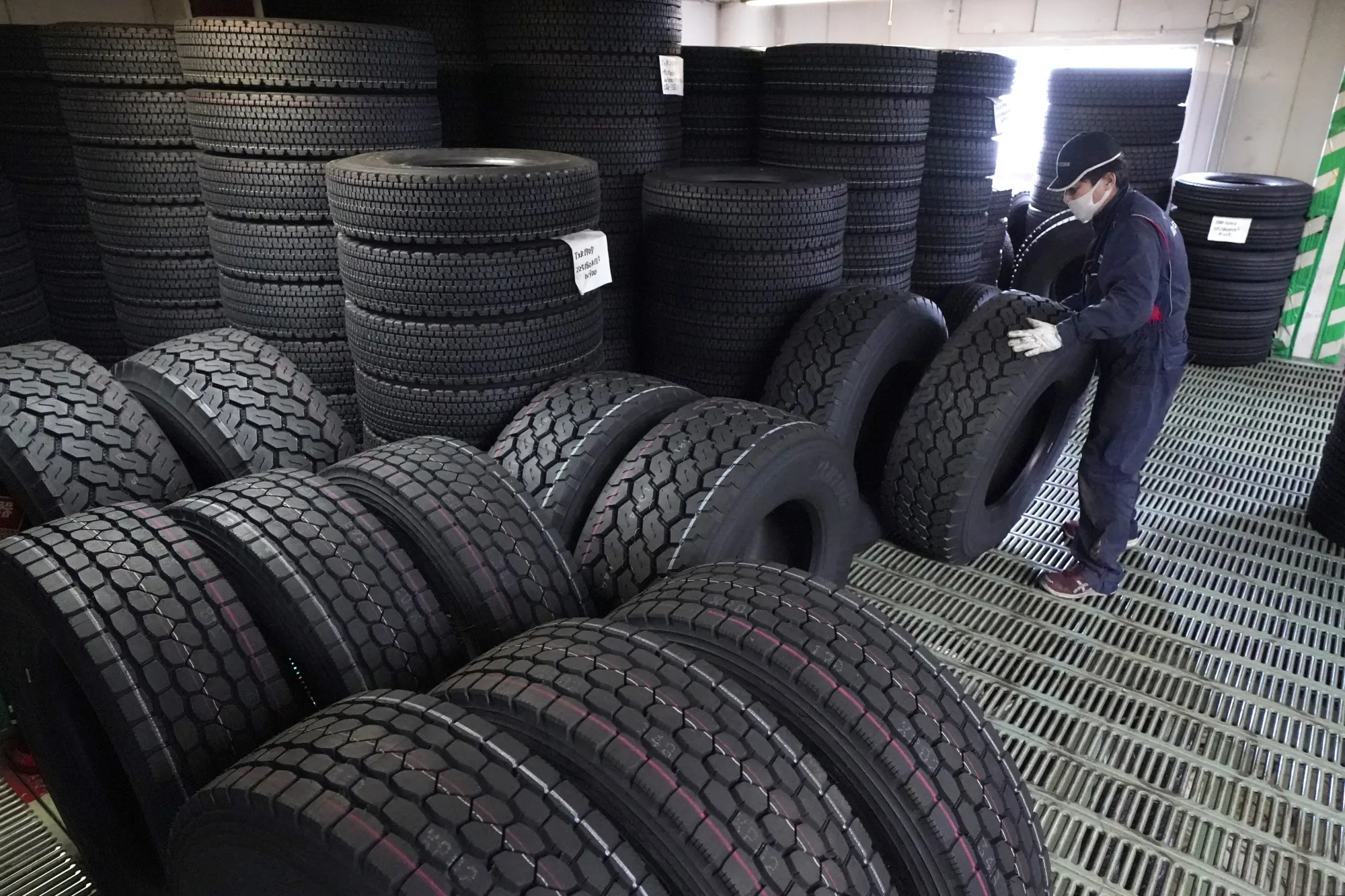 An employee handles a Bridgestone Corp's truck tire in a warehouse at the company's tire shop in Tokyo.