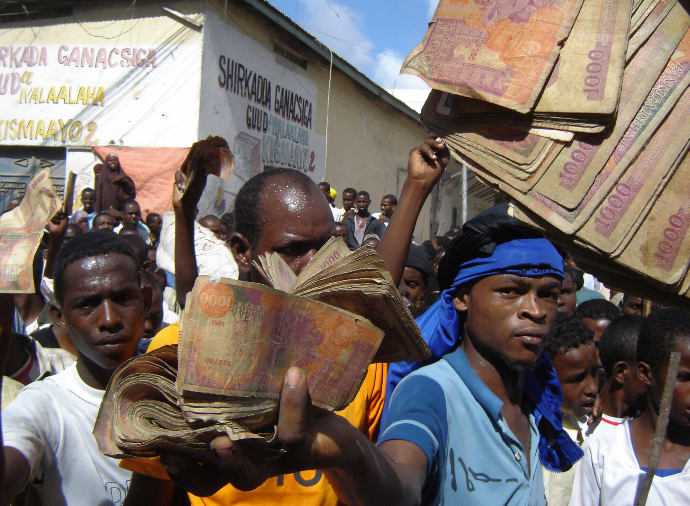 A crowd carry old notes during a demonstration against record-high inflation on May 5, 2008 in the country's capital, Mogadishu. At least five demonstrators were killed on May 5, when Somali security forces fired at crowds protesting rising food prices in Mogadishu, witnesses said. About 7,000 protestors accused unscrupulous traders of rejecting the Somali shilling in favor of the US dollar, thus pushing inflation to historic heights since the government collapsed 17 years ago. AFP PHOTO/ MUSTAFA ABDI (Photo credit should read MUSTAFA ABDI/AFP/Getty Images)
