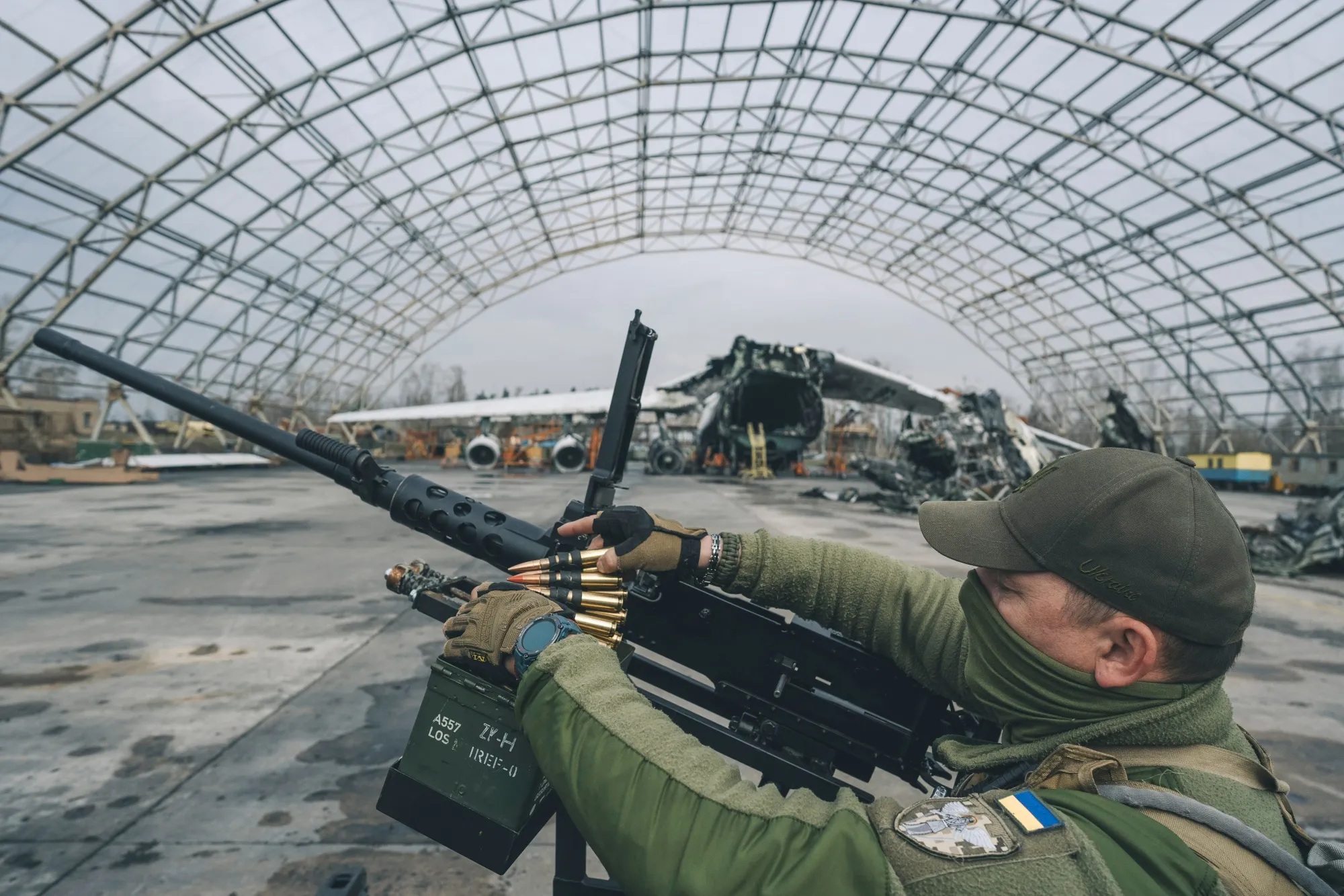 A Ukrainian soldier loads ammunition into an M2 Browning machine gun.