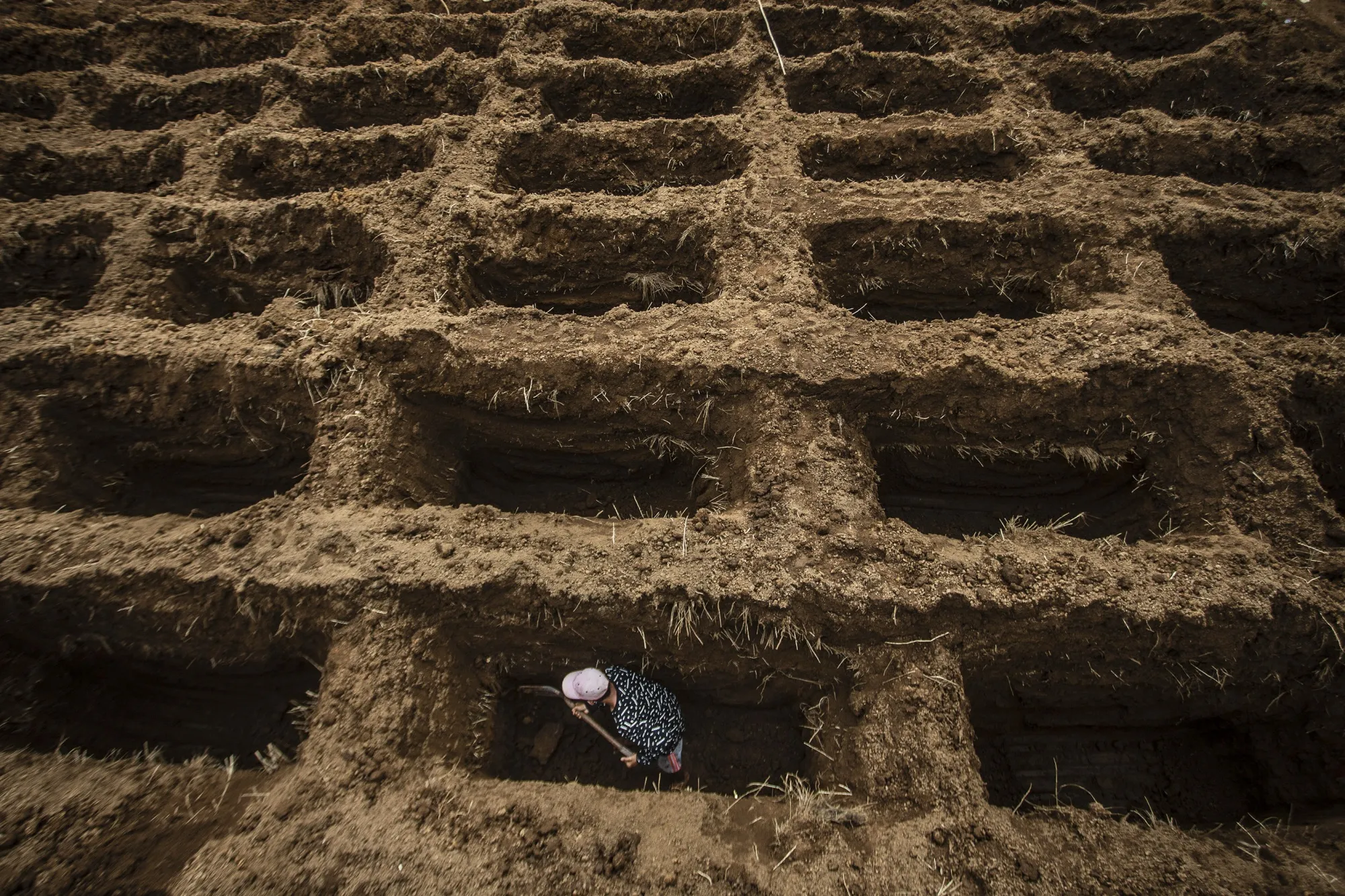 A worker digs graves for Covid-19 victims in Bogor, Indonesia.