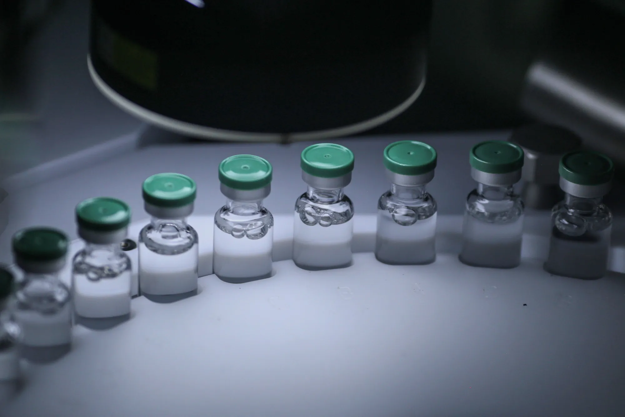 Vials of a vaccine move along a conveyor on a production line.