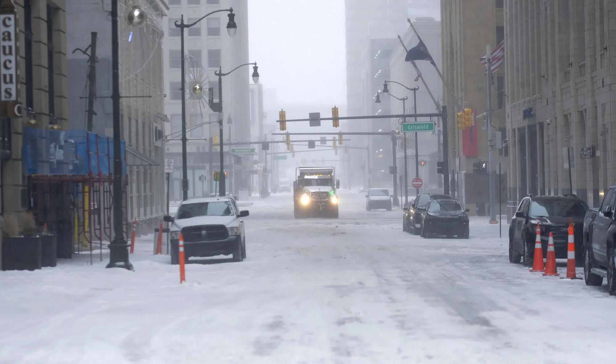 Vehicles try to clear roads in downtown Detroit on Dec. 23.
