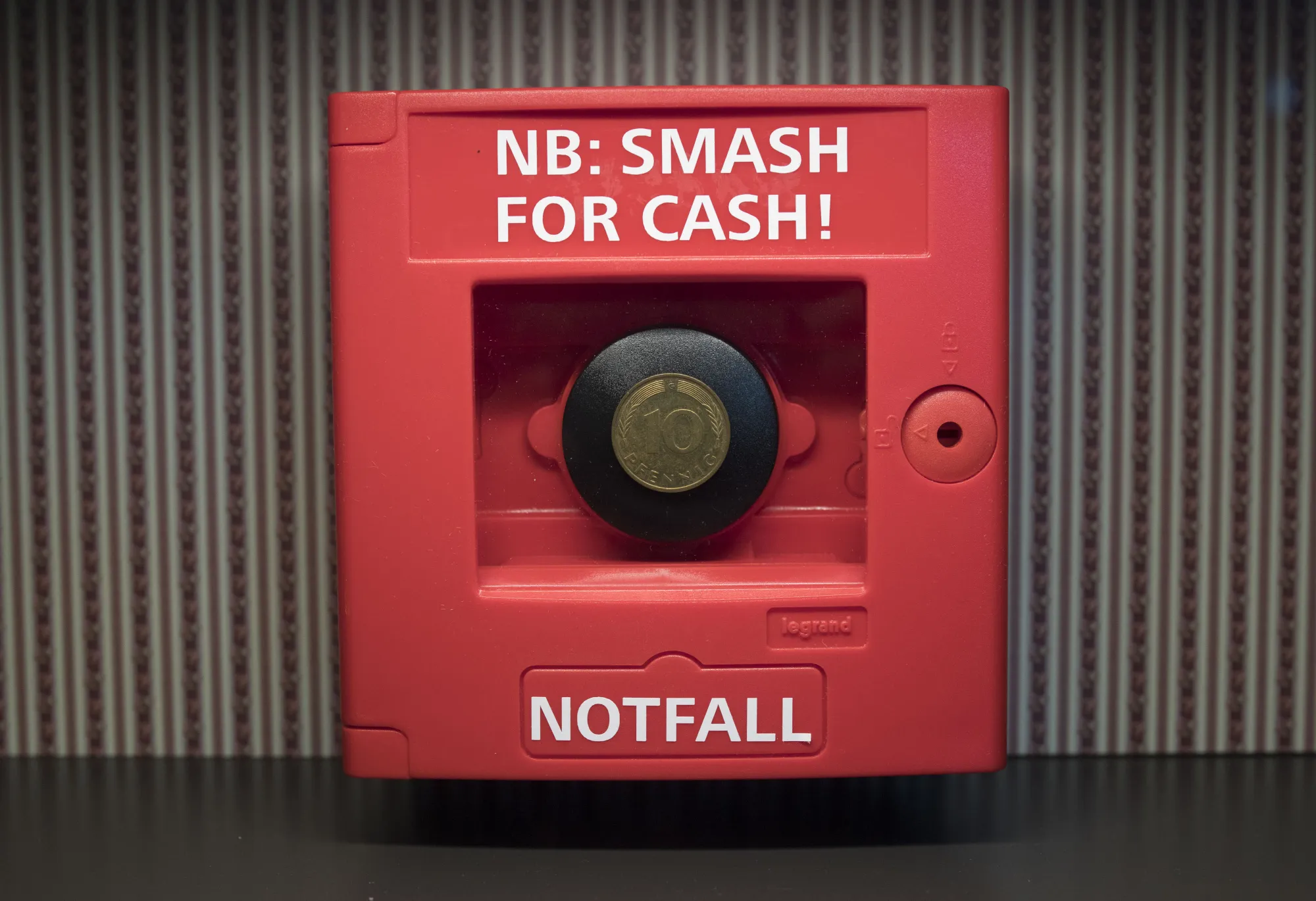 An historic ten pfennig coin sits inside an emergency box reading "Smash for Cash" at the Deutsche Bundesbank's money museum in Frankfurt.
