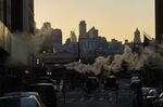 Steam rises above vehicles near the New York Stock Exchange (NYSE) in New York, U.S., on Thursday, Dec. 27, 2018.