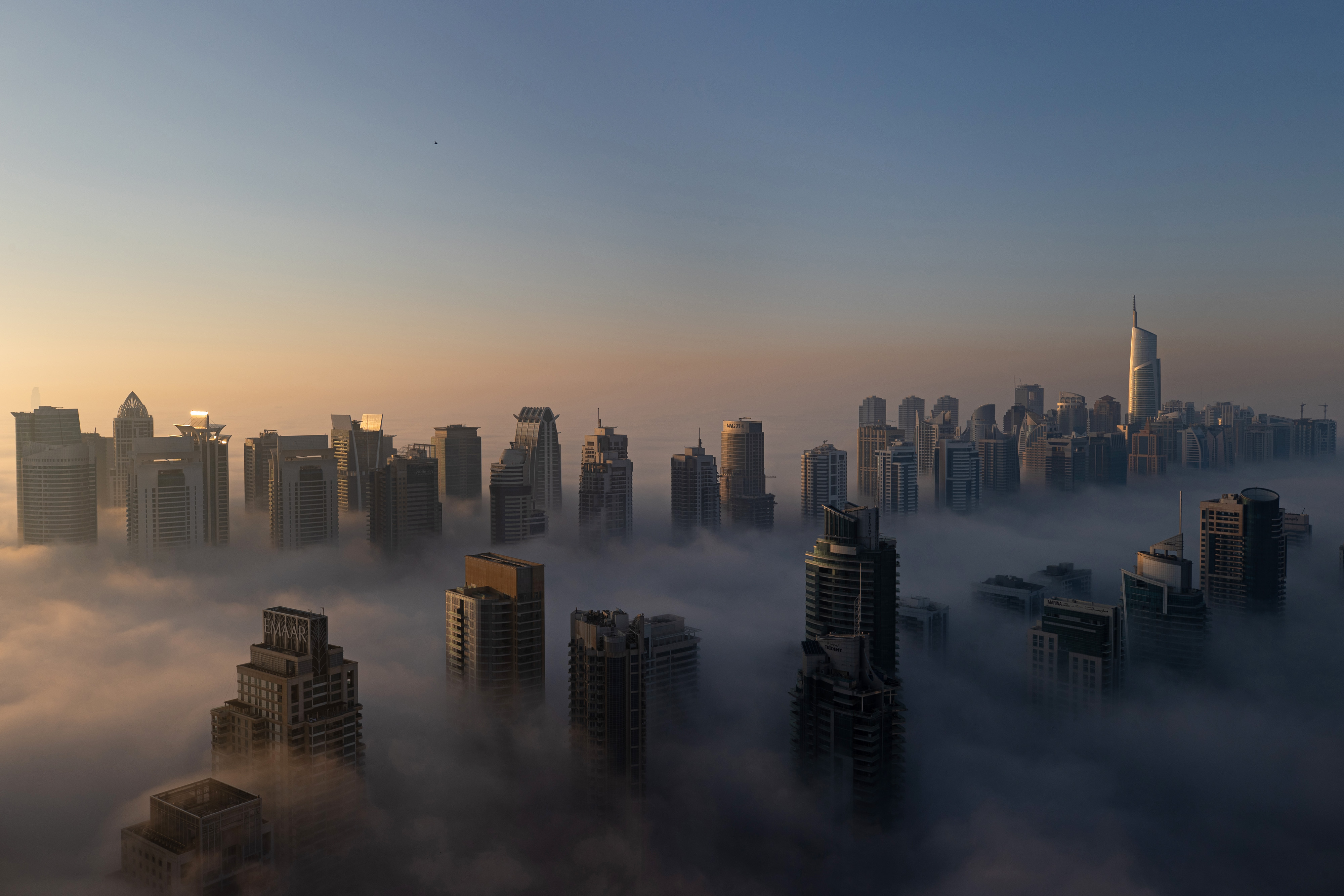 Residential and commercial skyscrapers stand among morning fog in the Jumeirah Lakes Towers and Dubai Marina districts of Dubai, United Arab Emirates, on Sunday, Jan. 17, 2021. Dubai is hoping one of the world’s fastest vaccination programs and rapid testing technology will help achieve its goal of holding the Expo 2020 event this year, after the coronavirus pandemic forced a delay.