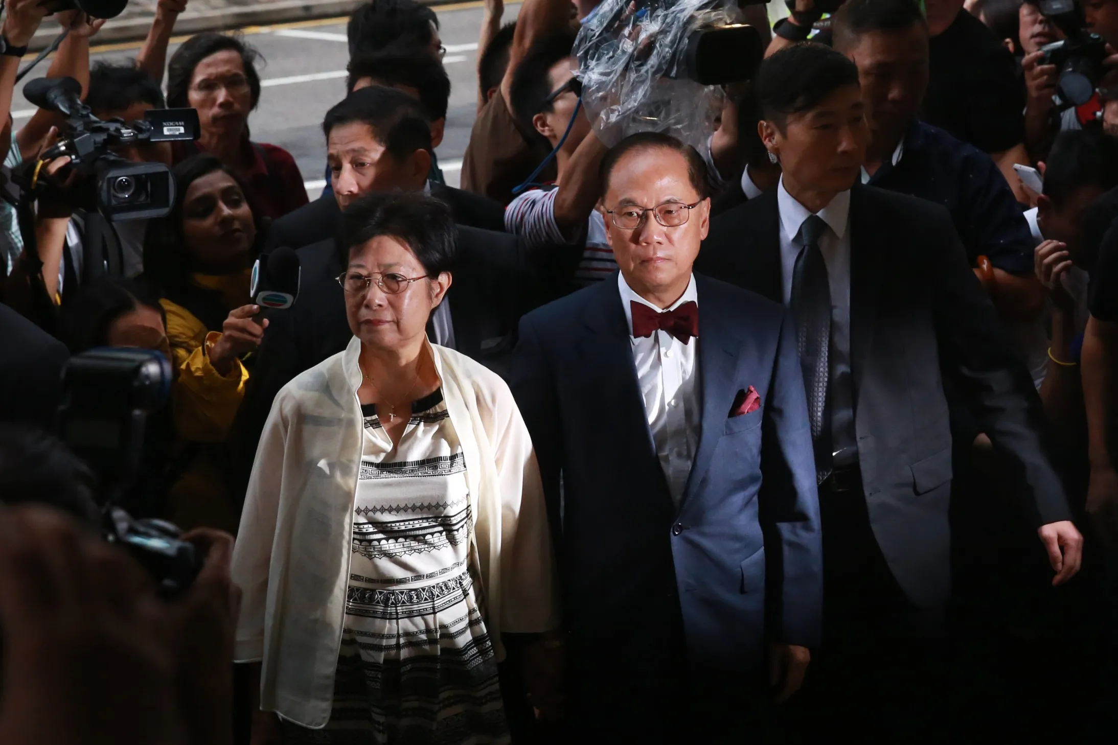 Donald Tsang, Hong Kong's former chief executive, center right, and his wife Selina Tsang arrive at the Eastern Magistrates' Court in Hong Kong on Monday.
