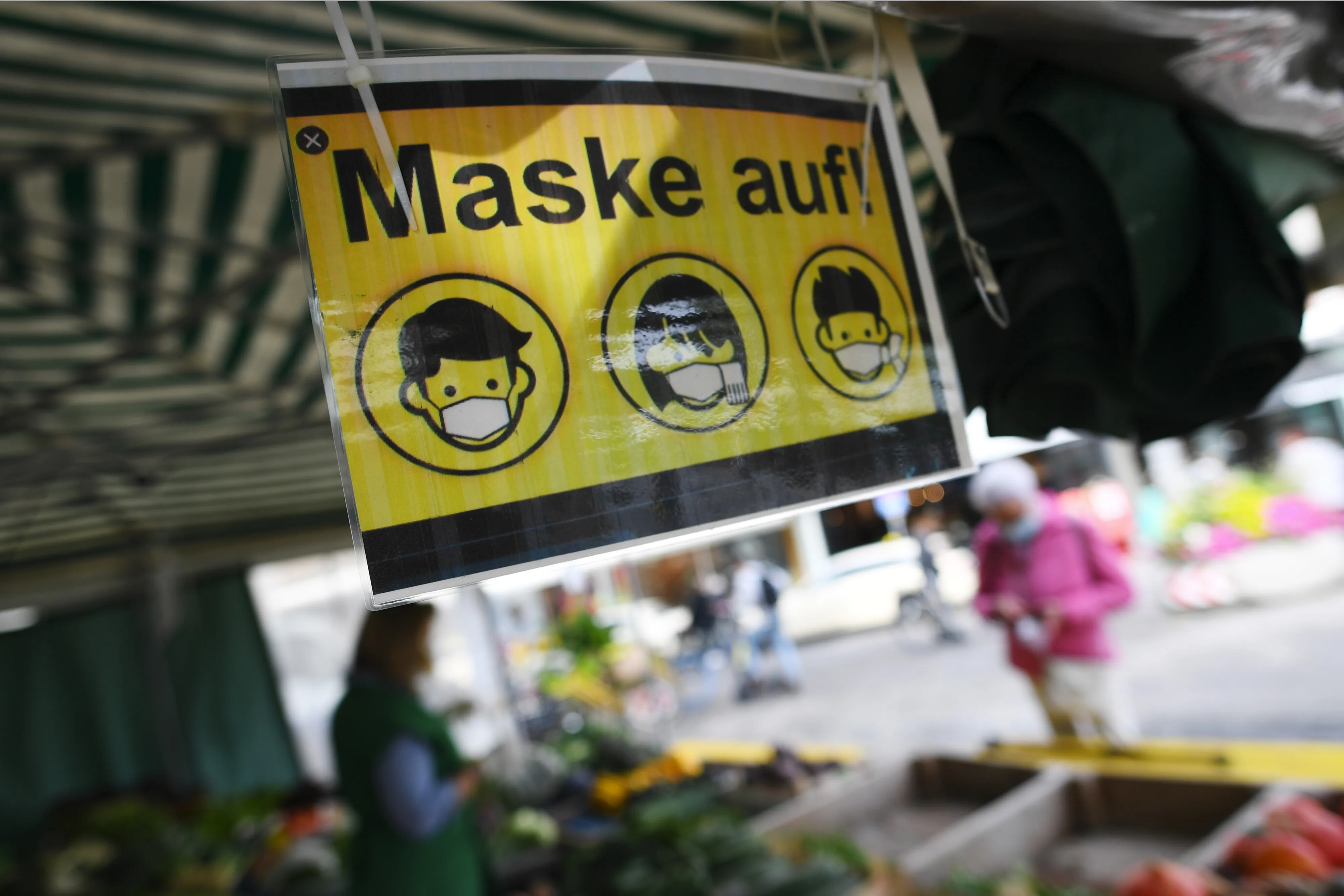 A sign informs shoppers&nbsp;to keep masks on at a fruit and vegetable stall at Viktualienmarkt in Munich.