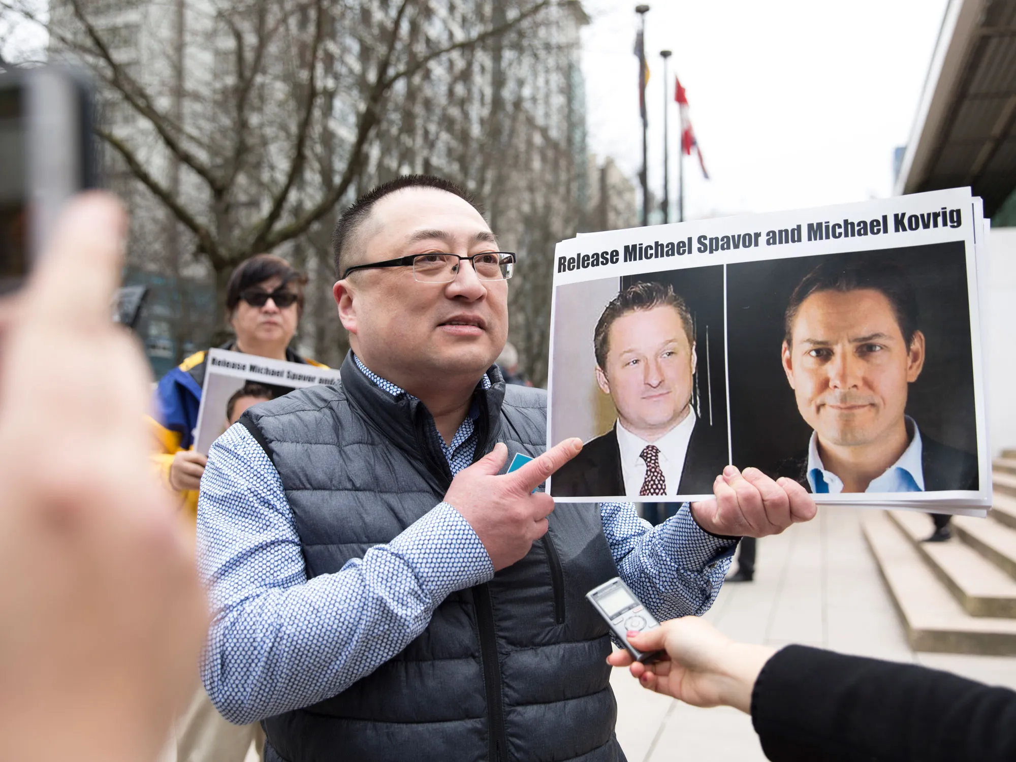 Photos of Michael Spavor and Michael Kovrig are held in Vancouver in March.
