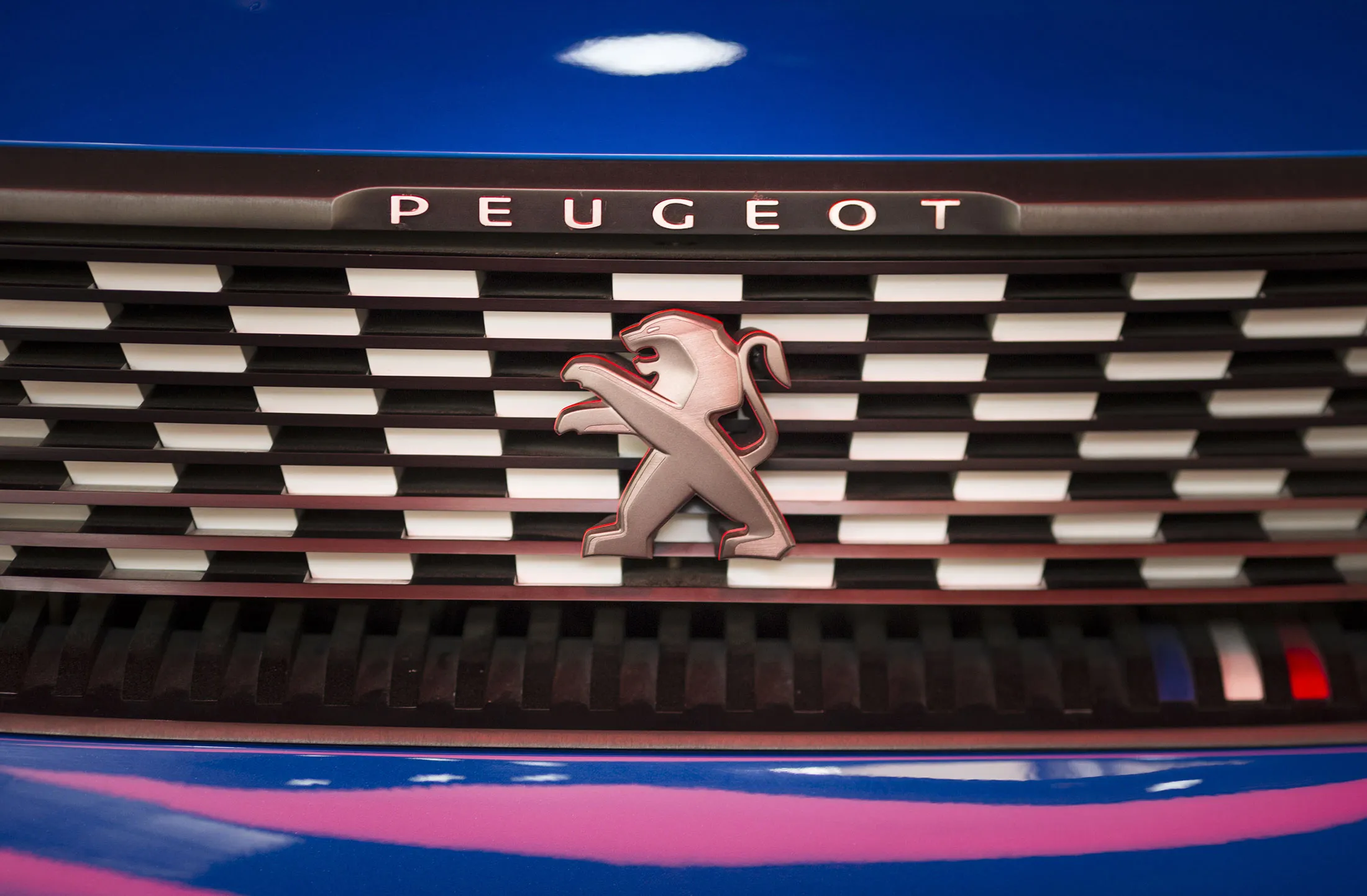 The Peugeot lion badge sits on the front grill of a Peugeot Quartz concept automobile inside the PSA Peugeot Citroen automobile showroom on the Avenue des Champs-Elysee in Paris, France, on Wednesday, July 29, 2015. Renault SA shares fell the most in almost four years after its first-half profit gain failed to keep pace with fellow French carmaker Peugeot.
