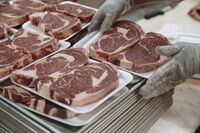 A worker stacks beef steaks on a tray in the butcher section at supermarket in Paramus, New Jersey.