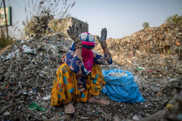 A worker sorts through a pile of plastic discarded from a paper mill, identifying metal and other items to recycle at a plastic scrap contractors yard, in Muzaffarnagar District, Uttar Pradesh, India, on Thursday, Nov. 17, 2022.