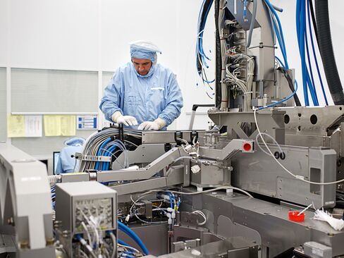 An employee assembles a photolithography machine at the ASML Holding NV factory in Veldhoven, Netherlands.
