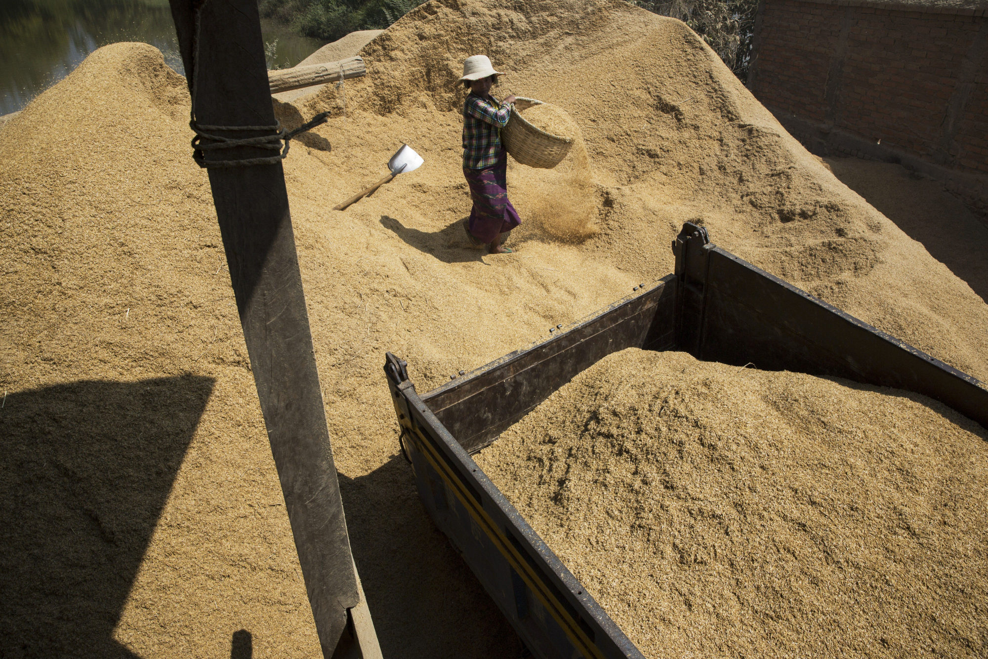 A worker collects baskets of rice husks at a rice mill near Kengtung, Shan State, Myanmar.