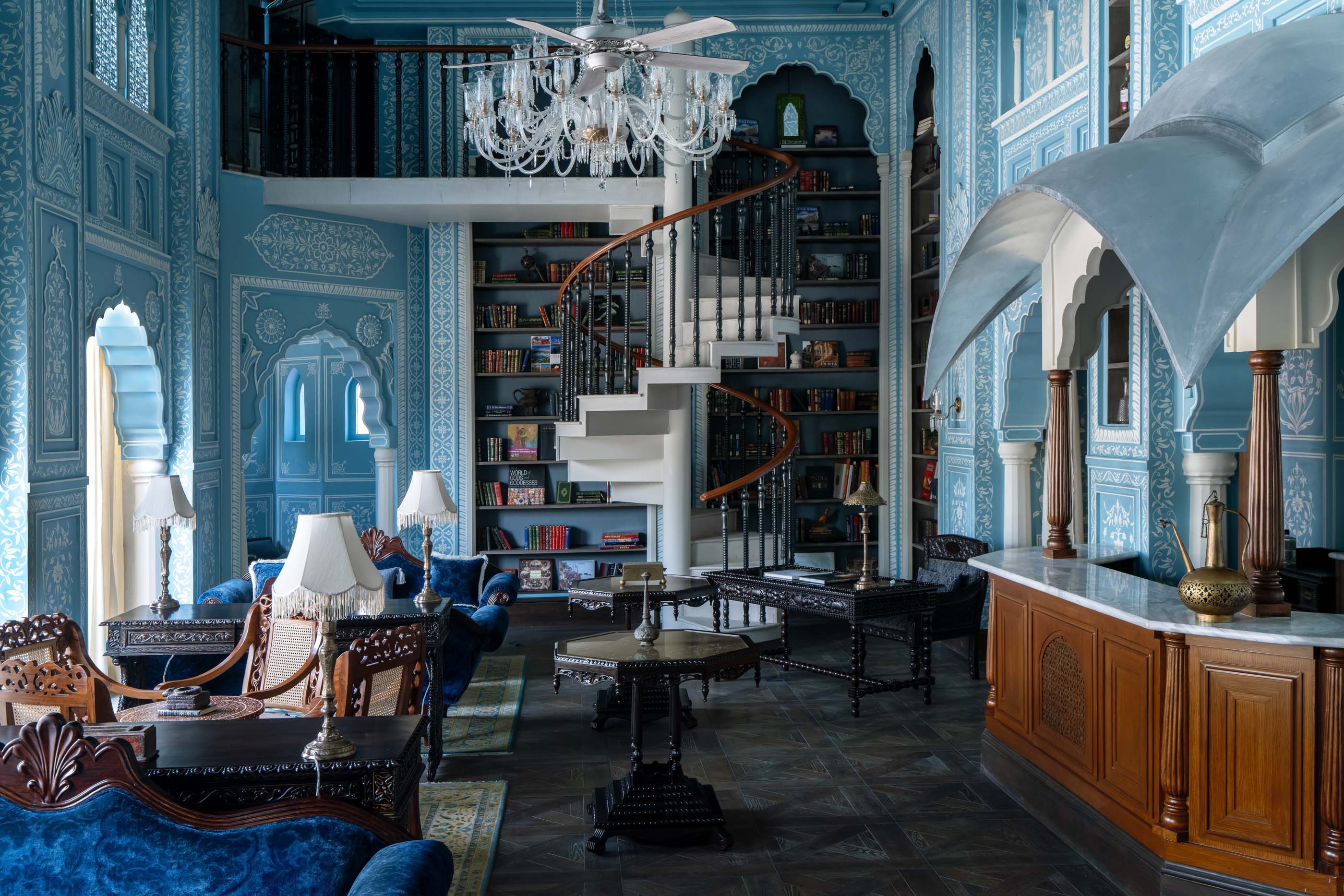 An intricately embellished, blue-and-white library that doubles as a bar at the Raffles Jaipur.