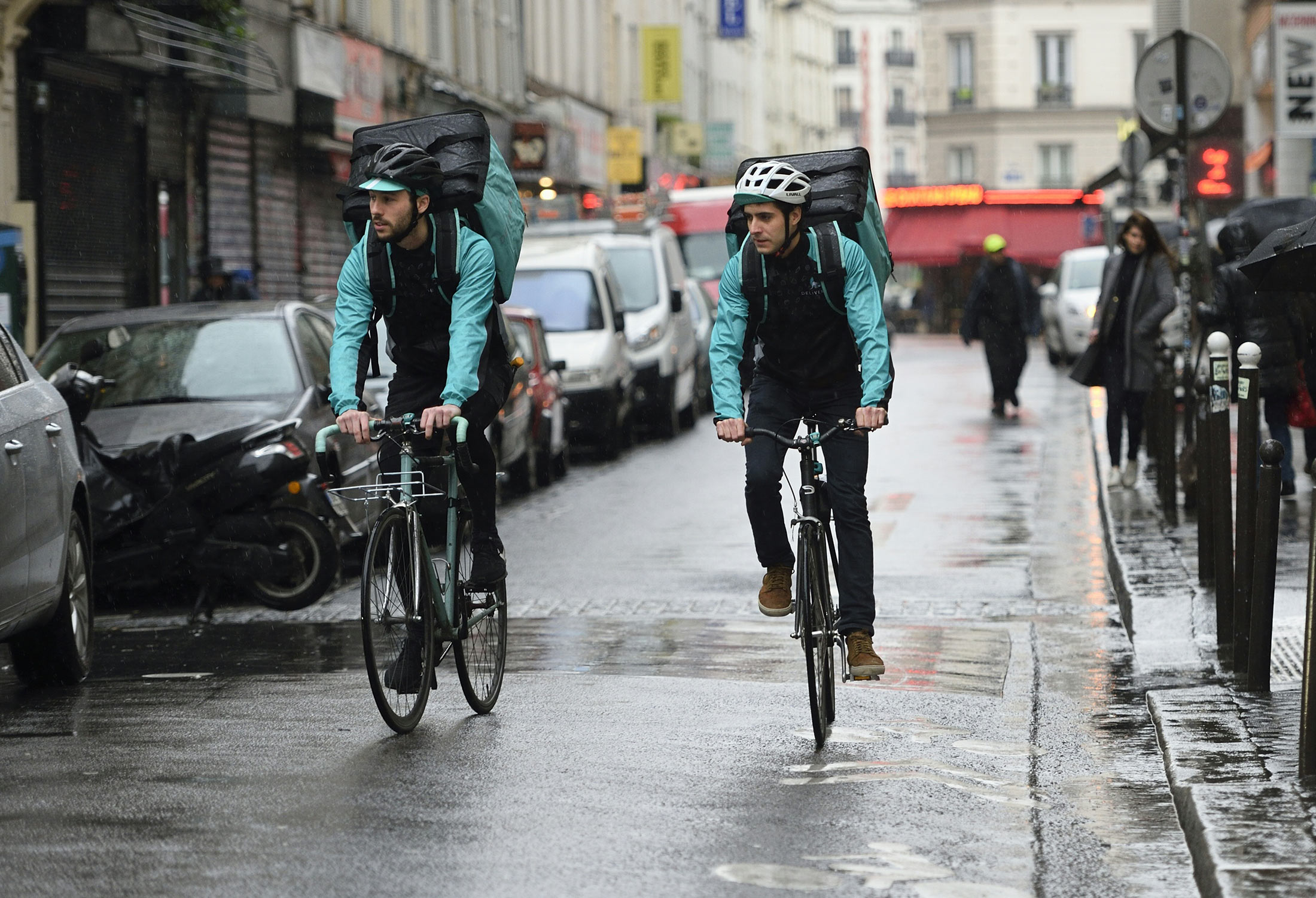 Bikers working for food delivery service Deliveroo deliver meals in Paris.
